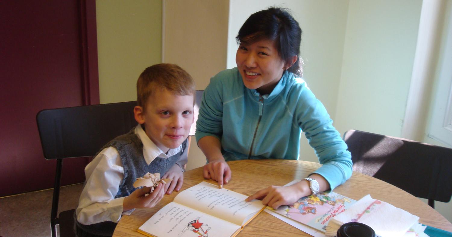 A student tutoring a child at an afterschool club A student tutoring a child at an afterschool club